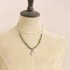 A mannequin wearing the knotted elisa turquoise, peridot, and peach blossom necklace