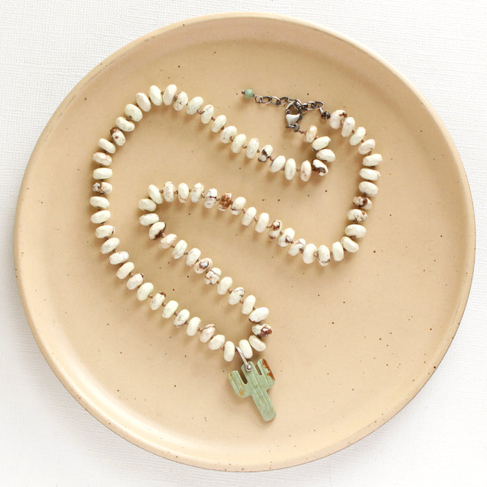 The knotted lemon chrysoprase and carved turquoise cactus necklace styled on a tan plate to show the adjustable lobster clasp closure
