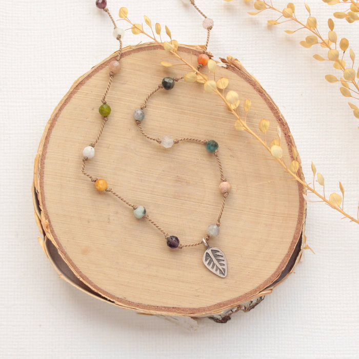 The knotted kaleidoscope necklace styled on wood with dried grass
