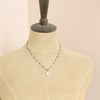A mannequin wearing the knotted ruby and moonstone necklace