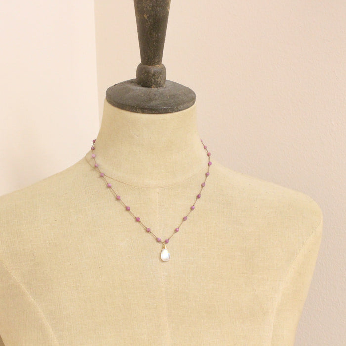 A mannequin wearing the knotted ruby and moonstone necklace