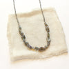 The knotted opal necklace styled on tan linen