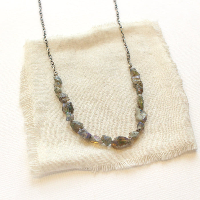 The knotted opal necklace styled on tan linen