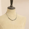A mannequin wearing the knotted opal necklace
