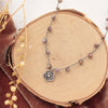 The knotted phosphosiderite mini cactus flower necklace styled on wood with orange velvet and dried grass