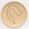 The knotted phosphosiderite mini cactus flower necklace styled on a tan plate to show the adjustable lobster clasp closure