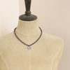 A mannequin wearing the knotted purple ruby layered cactus flower necklace