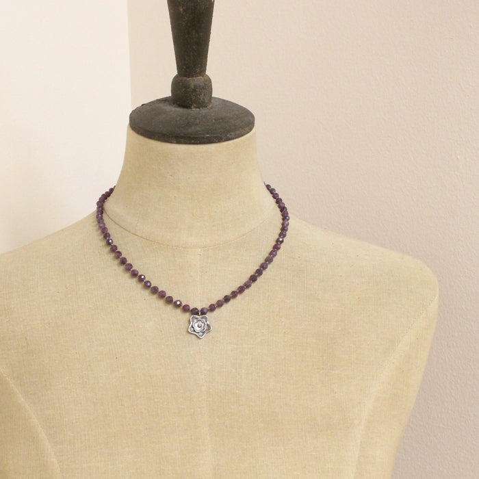 A mannequin wearing the knotted purple ruby layered cactus flower necklace