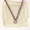 The knotted purple ruby layered cactus flower necklace styled on tan linen