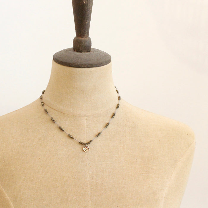A mannequin wearing the knotted pyrite and bronze cactus flower necklace