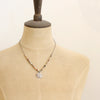 A mannequin wearing the knotted rainbow agate sun cross necklace