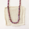 The knotted ruby nugget necklace styled on tan linen