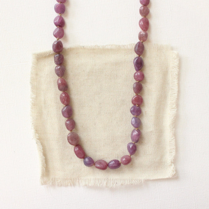The knotted ruby nugget necklace styled on tan linen