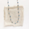 The knotted aquamarine necklace styled on tan linen
