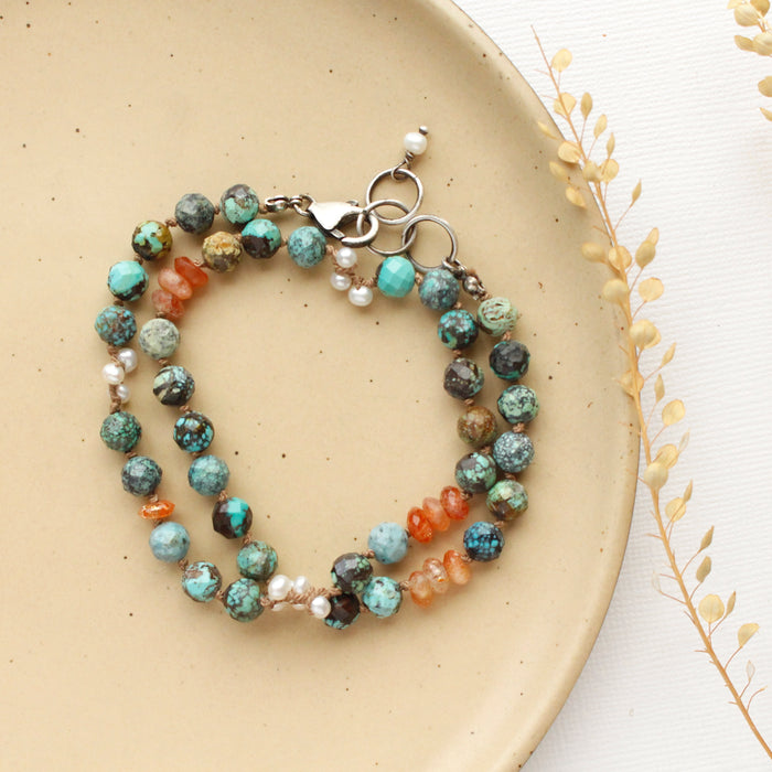 The knotted sunset bracelet styled on a tan plate with dried grass