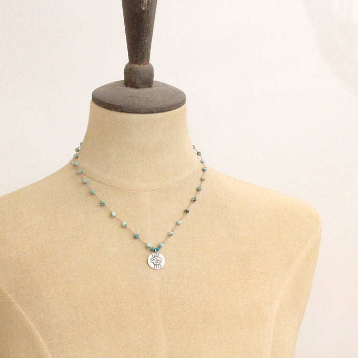 A mannequin wearing the knotted turquoise soar necklace