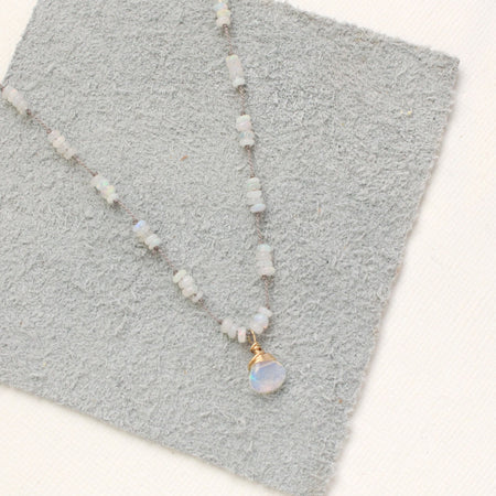 The knotted opal necklace styled on gray leather