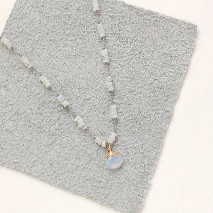 The knotted opal necklace styled on gray leather