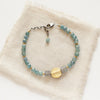 The mythos bracelet styled on tan linen