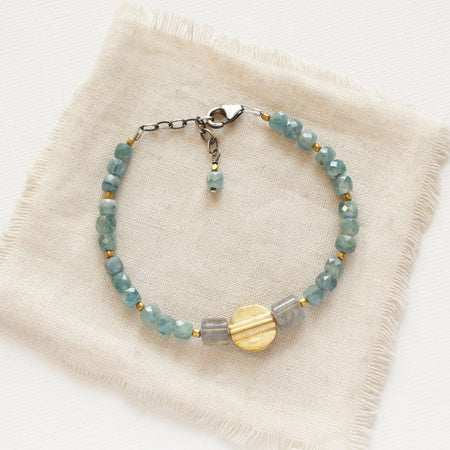 The mythos bracelet styled on tan linen