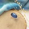 The kyanite ring styled on wood with blue velvet and dried grass