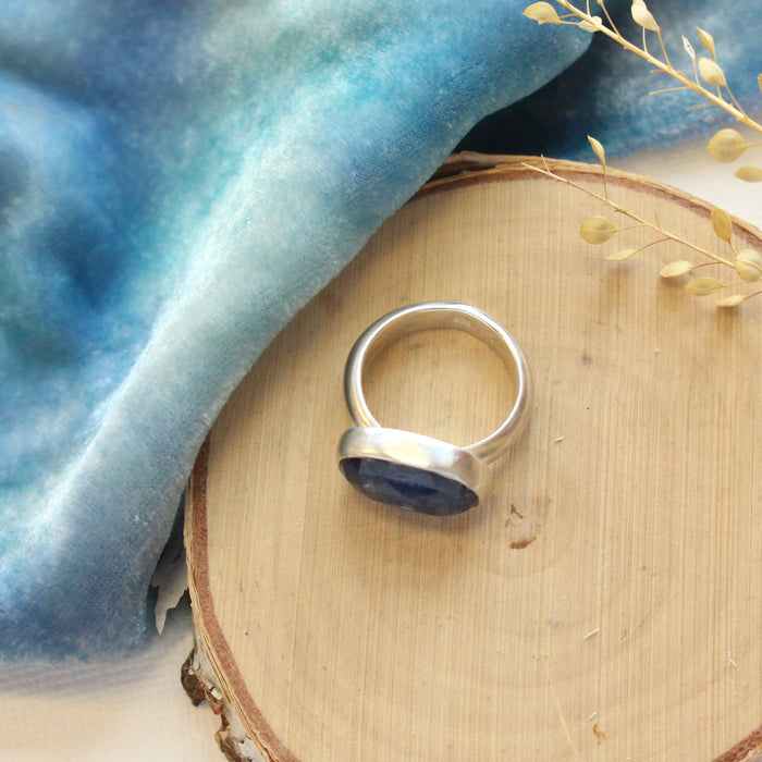 The kyanite ring styled on wood to show the silver band