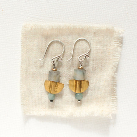 The stacked mythos earring styled on tan linen