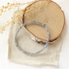 The labradorite cube stretch bracelet styled on wood with linen and dried grass