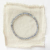 The labradorite cube stretch bracelet styled on tan linen