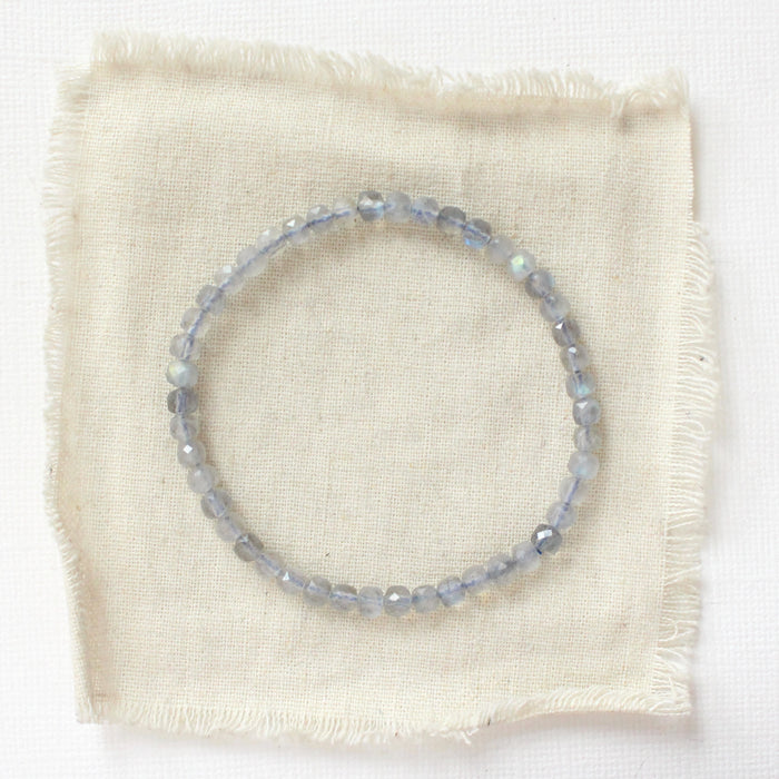 The labradorite cube stretch bracelet styled on tan linen