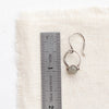 A labradorite la cloche earring next to a ruler for size reference