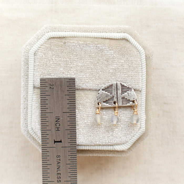 A labradorite pakal arch post earring next to a ruler for size reference