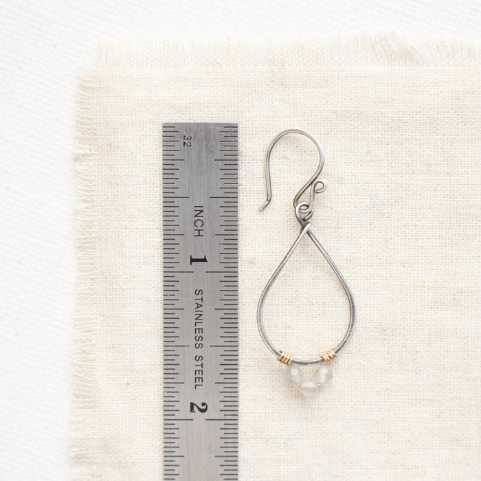 A labradorite wrapped teardrop hoop earring next to a ruler for size reference