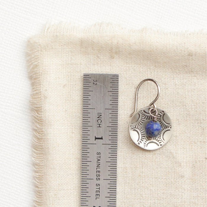 A lapis cupped jolie earring next to a ruler for size reference