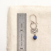 A lapis jolie earring next to a ruler for size reference