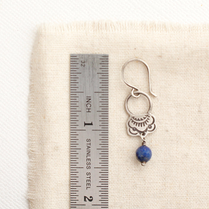 A lapis jolie earring next to a ruler for size reference