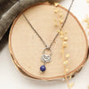 The lapis jolie necklace styled on wood with gray velvet and dried grass