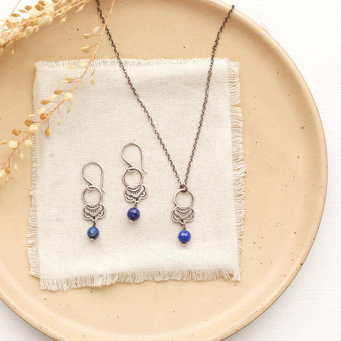 The lapis jolie necklace styled on a tan plate with the matching earrings
