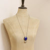 A mannequin wearing the lapis and brass leaf long necklace 