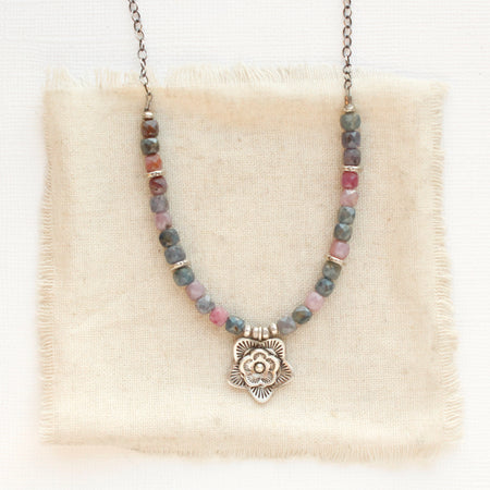 The layered cactus flower sapphire necklace styled on tan linen