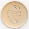 The layered mountain bar necklace styled on a tan plate to show the adjustable lobster clasp closure