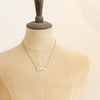 A mannequin wearing the oxidized silver mountain bar necklace