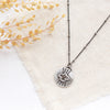 The layered soar necklace styled on tan linen with dried grass