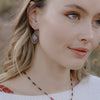 A model wearing the layered sprout earrings