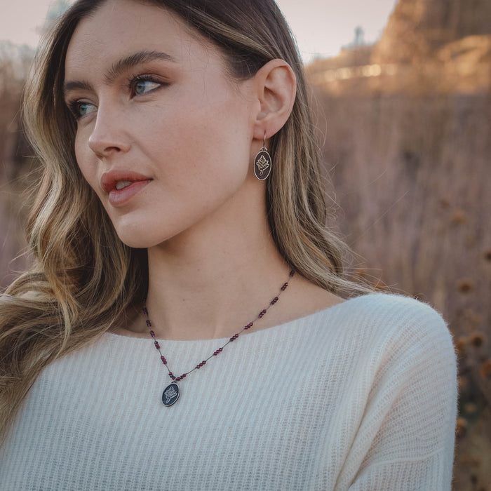 The layered sprout earrings on a model