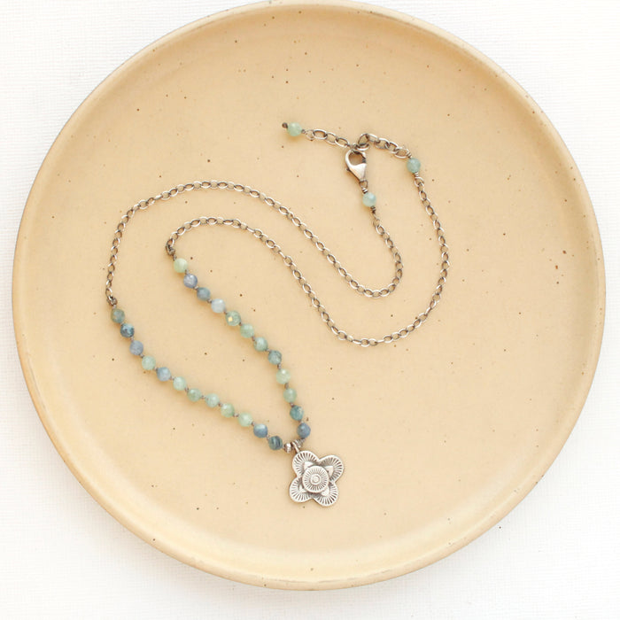 The layered talara knotted kyanite necklace styled on a tan plate to show the adjustable lobster clasp closure 