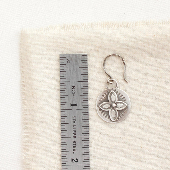 A layered wanderer coin earring next to a ruler for size reference