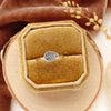 The leaf stacking ring styled in a yellow box on wood with orange velvet and dried grass