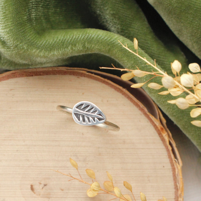 The leaf stacking ring styled on wood with green velvet and dried grass