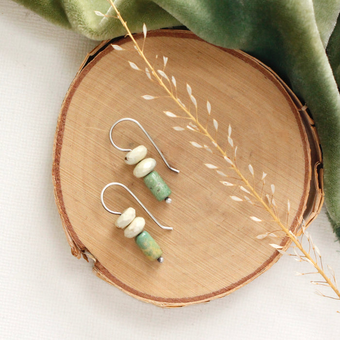 The turquoise and lemon chrysoprase lobe hugger earrings styled on wood with green velvet and dried grass